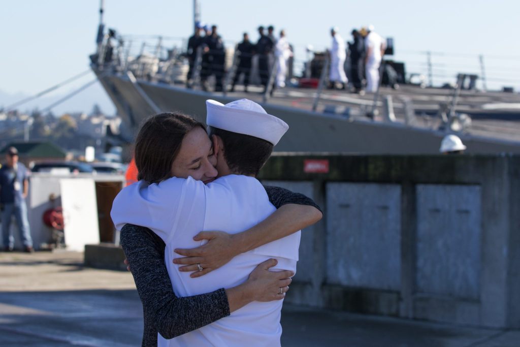 Ashley and Jesse Carpentier hug after the USS Sampson (DDG 102) docks at Naval Station Everett on Monday. (Andy Bronson / The Herald)