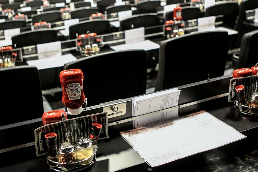 Empty seats and condiments await moviegoers at Cinebarre. (Kevin Clark / The Herald)