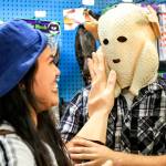Brittaney Dover, left, of Bellingham pats the masked face of Clifford Goff of Bellingham at the Archie McPhee store. (Kevin Clark / The Herald)