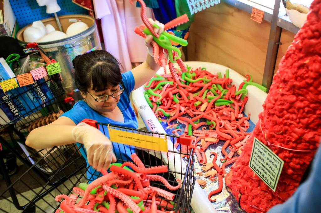 Jackie Sugita works to empty the tentacle display last month at Archie McPhee in the Wallingford neighborhood of Seattle. (Kevin Clark / The Herald)