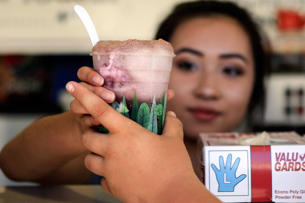 Tina Nguyen hands over a Purple Cow float on the first day of the fair in Monroe. (Kevin Clark / The Herald)
