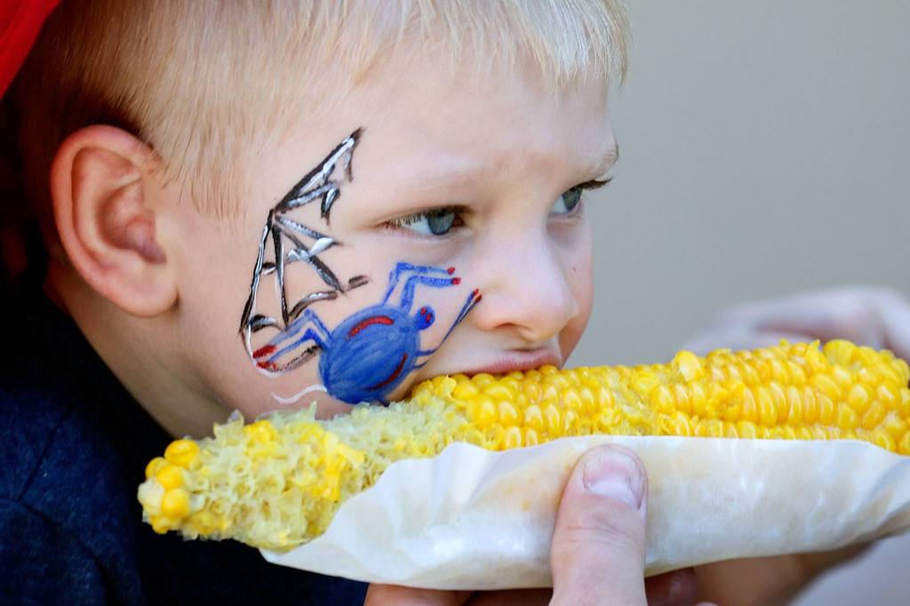 Lincoln Pillar, 4, enjoys corn on the cob from the Nile Shriners&rsquo; stand at the fair. (Kevin Clark / The Herald)