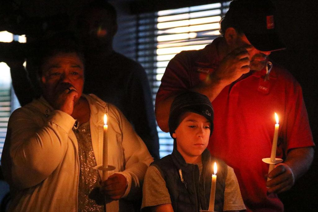 Priscilla Burns (from left), Ezekiel Burns and Robert Burns remembers a departed family member during the candlelight vigil held by Hope Soldiers in honor of International Overdose Awareness Day at Mukilteo Foursquare Church in August. (Kevin Clark / The Herald)