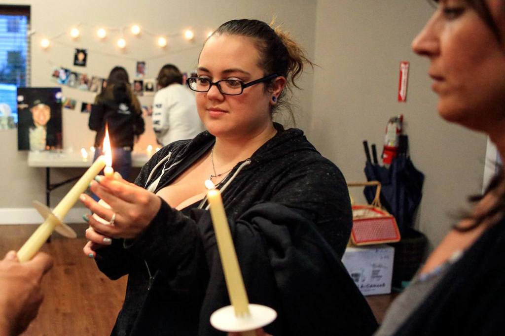 Delane Caudel lights candles for the candlelight vigil held by Hope Soldiers in honor of International Overdose Awareness Day at Mukilteo Foursquare Church in August. (Kevin Clark / The Herald)