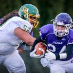 Kamiak&rsquo;s Ben Barton rushes to escape a tackle attempt by Bishop Blanchet&rsquo;s Aarenn Savelio Friday night at Goddard Stadium in Everett. (Kevin Clark / The Herald)