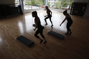 Wellness Instructors Michelle Chavez, left, Andrea Maldonado and Julie Holmes warm up for a step class demonstration before the Grand Opening of the Stanwood-Camano YMCA on Sept. 3, 2016, in Stanwood. (Andy Bronson / The Herald)