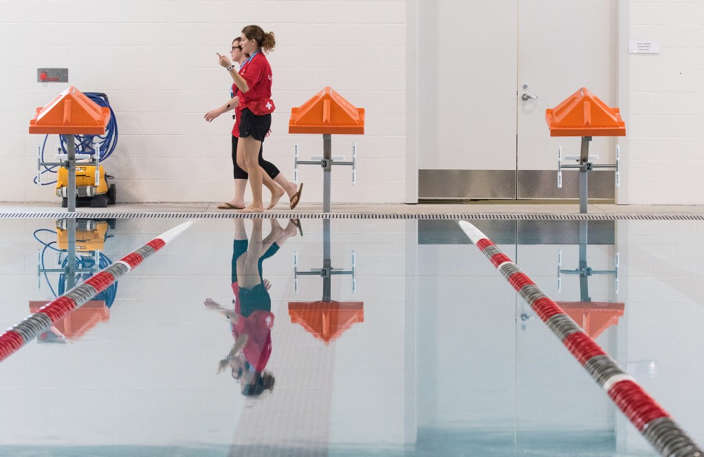 Lifeguards Mikaela Cleland and Sierra Jones head to their posts during the Grand Opening of the Stanwood-Camano YMCA on Sept. 3, 2016, in Stanwood. (Andy Bronson / The Herald)