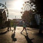 Evening light casts shadows on attendants of the Evergreen State Fair. (Ian Terry / The Herald)