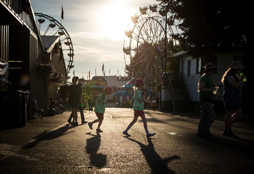 Evening light casts shadows on attendants of the Evergreen State Fair. (Ian Terry / The Herald)