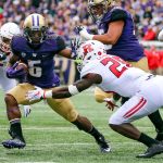 Washington&rsquo;s Chico McClatcher runs for additional yard with Rutgers&rsquo; Najee Clayton closing Saturday afternoon Husky Stadium. (Kevin Clark / The Herald)