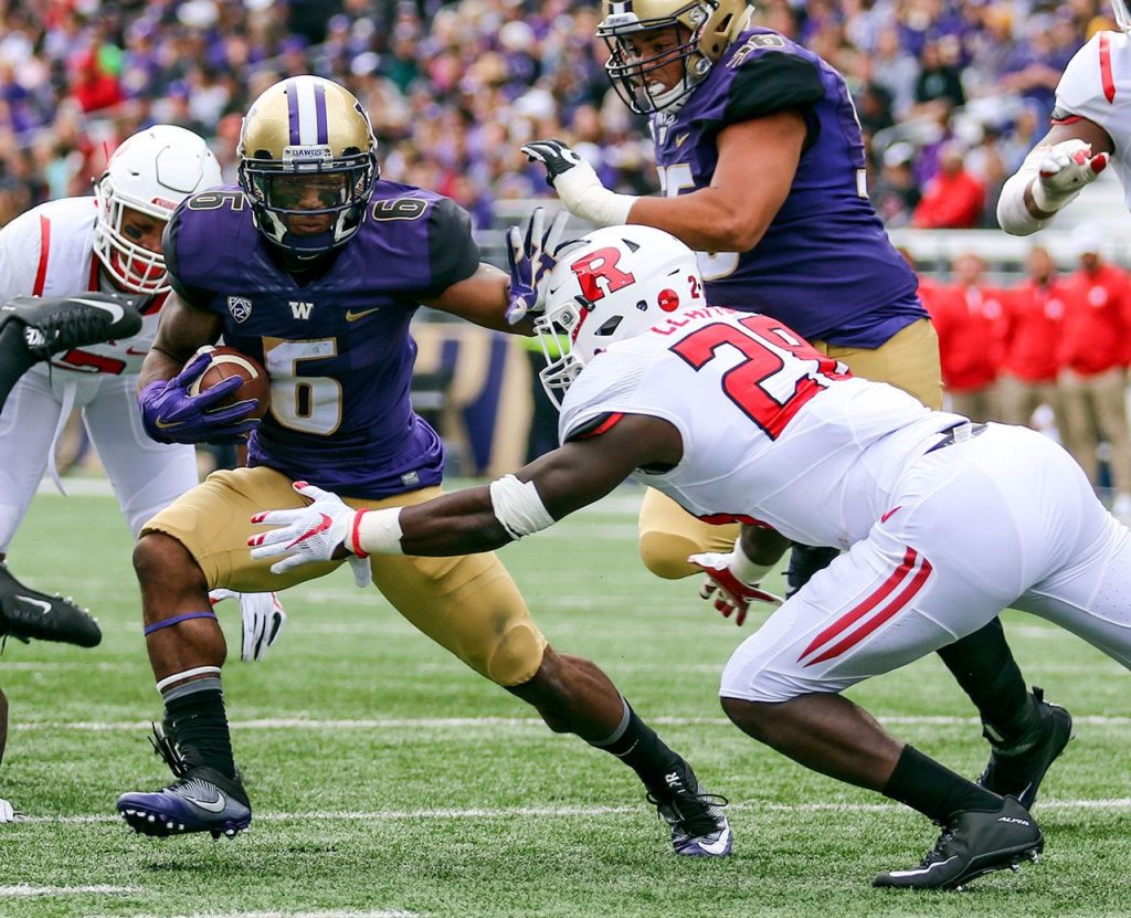 Washington&rsquo;s Chico McClatcher runs for additional yard with Rutgers&rsquo; Najee Clayton closing Saturday afternoon Husky Stadium. (Kevin Clark / The Herald)