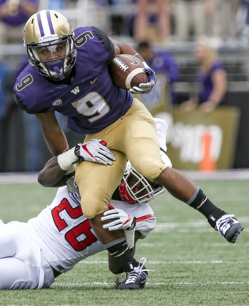Husky Myles Gaskin is tackled by Rutgers Deonte Roberts Saturday afternoon at Alaska Airlines Field at Husky Stadium on September 3, 2016. The UW Huskies defeated the Rutgers Scarlet Knights 48-13. (Kevin Clark / The Herald)