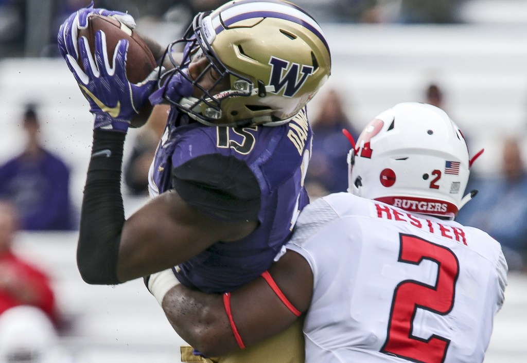 Husky Darrell Daniels makes a reception with Rutgers Kiy Hester tackling Saturday afternoon at Alaska Airlines Field at Husky Stadium on September 3, 2016. The UW Huskies defeated the Rutgers Scarlet Knights 48-13. (Kevin Clark / The Herald)