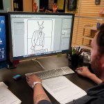 Scott Heffernan works on a design for an adult coloring book at the Archie McPhee warehouse in Mukilteo. Among his other duties at the company that include coming up with new products, illustration and product photography, Heffernan&rsquo;s hand was also used as the model for the popular finger hand toys. (Ian Terry / The Herald)