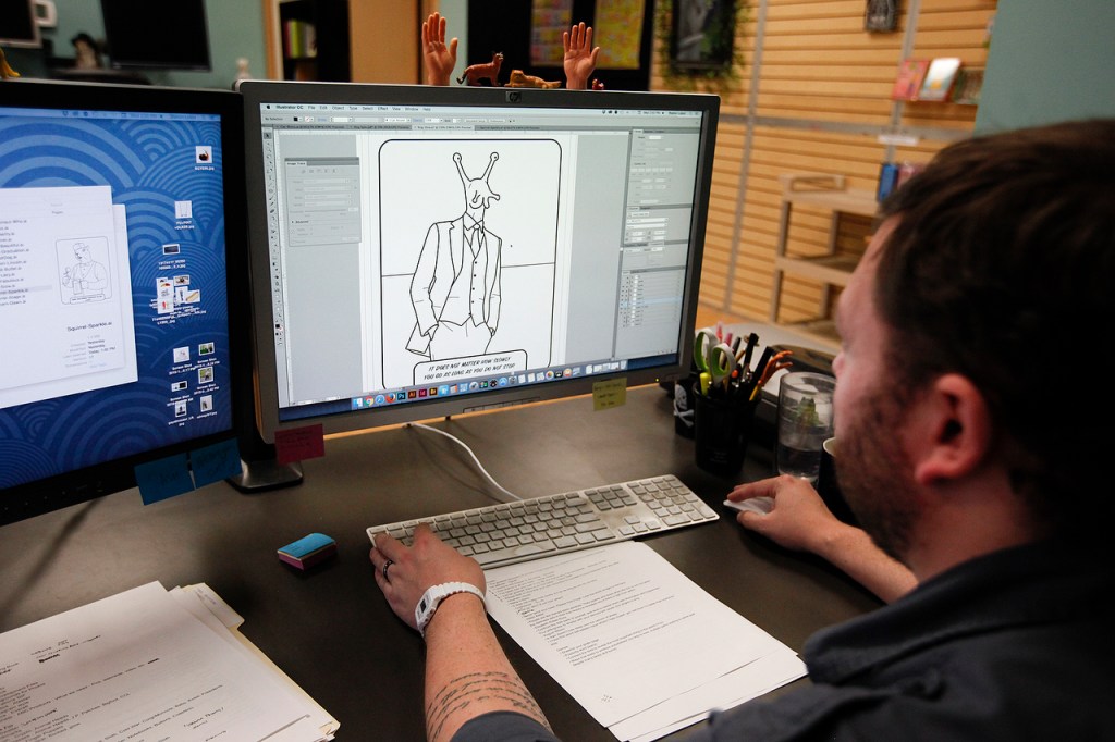 Scott Heffernan works on a design for an adult coloring book at the Archie McPhee warehouse in Mukilteo. Among his other duties at the company that include coming up with new products, illustration and product photography, Heffernan&rsquo;s hand was also used as the model for the popular finger hand toys. (Ian Terry / The Herald)