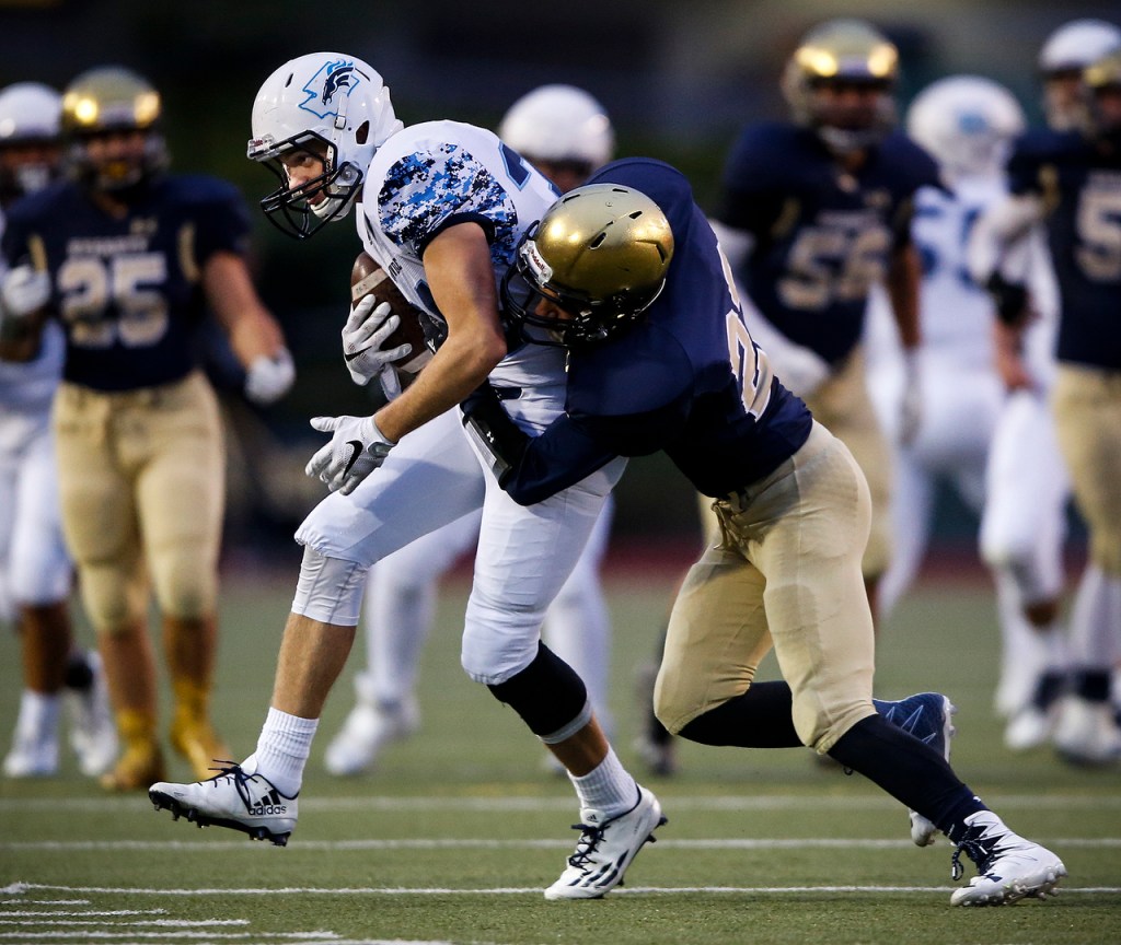 Meadowdale&rsquo;s Zach Plummer (left) pushes through Everett&rsquo;s Scotty Fermo during a game at Everett Memorial Stadium on Friday. (Ian Terry / The Herald)