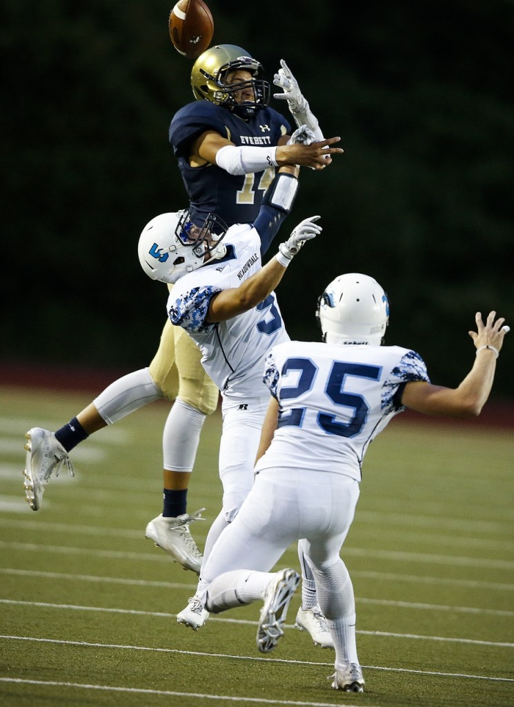 Meadowdale&rsquo;s Haelin Roberts (5) and Matthew Johnson (25) break up a pass intended for Everett&rsquo;s Elijah Ross-Rutter (14) during a game at Everett Memorial Stadium on Friday. (Ian Terry / The Herald)