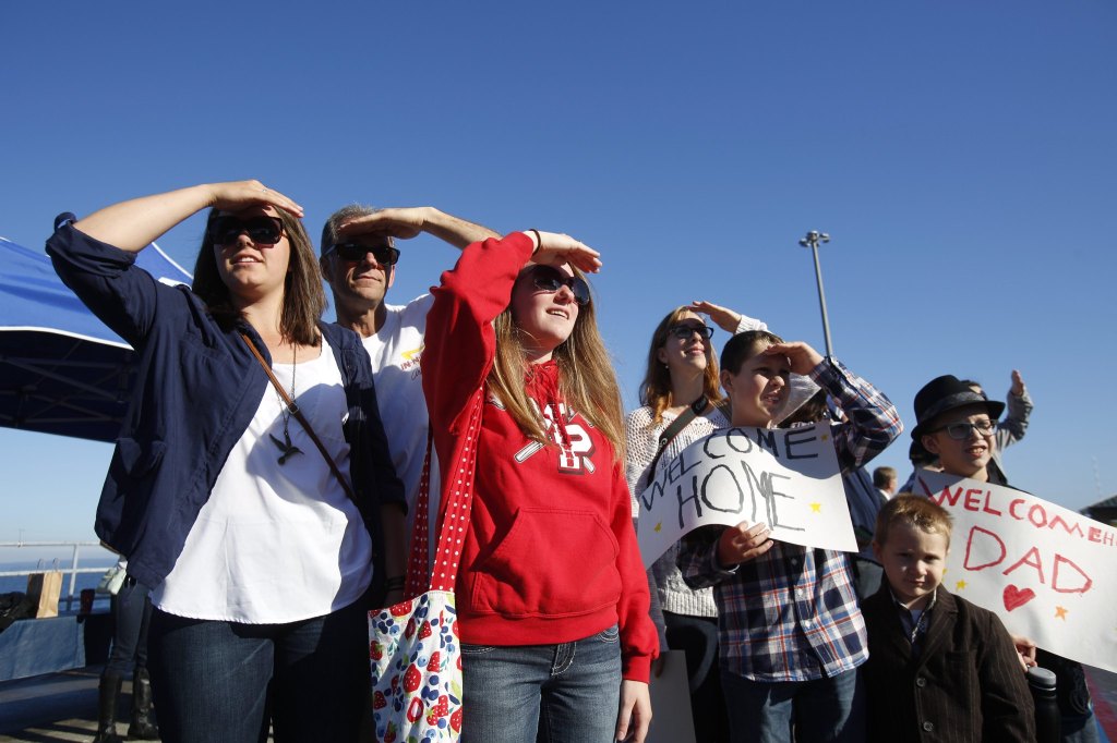 Friends and family look for loved ones as the USS Sampson (DDG 102) arrives at Naval Station Everett on Monday. (Andy Bronson / The Herald)