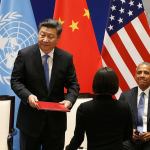 Chinese President Xi Jinping stands up to hand over documents for the ratification of the Paris climate change agreement as U.S. President Barack Obama looks on in Hangzhou, China, on Saturday. (How Hwee Young / Associated Press)