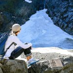 Connie Peterson looks out at the snowpack at the Big Four Ice Caves in Granite Falls on May 1. At right is a memorial plaque to Grace Tam, 11, who died July 31, 2010, after she was struck by a piece of ice while visiting the site with her family. (Kevin Clark / The Daily Herald, file)