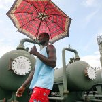 In this 2006 photo, Former security guard Esakpo Henry visits the oil flow station where he worked before in Eriemu, Nigeria. Officials say Nigeria is suing several oil majors for $12.7 billion of oil allegedly exported illegally to the United States between 2011 and 2014. (AP Photo/George Osodi, File)