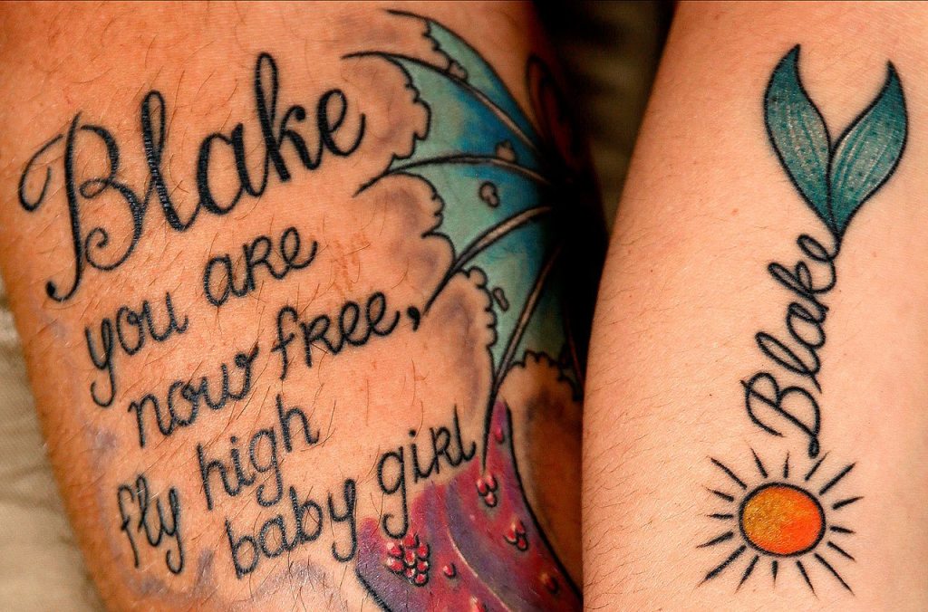 Jeff and Stephanie Reid got tattoos a few days after their daughter died. The sun on Stephanie&rsquo;s arm is about Blake being their sunshine. The butterfly on Jeff&rsquo;s arm represents the transformation that Blake has made, a kind of metamorphosis. The fins on Stephanie&rsquo;s arm are a mermaid tail. Blake loved being in water, Stephanie said. Out of water, she couldn&rsquo;t move her legs, but in water she could, and she loved it. (Dan Bates / The Herald)