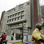 In this 2006 file photo, motorbike riders drive pass the Agip oil company head office building in Lagos, Nigeria. (AP Photo/George Osodi, File)