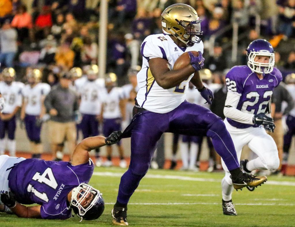 Oak Harbor&rsquo;s Princeton Lollar Jr. rushes for yardage with Kamiak&rsquo;s Jackson Finnerty holding on and Kamiak&rsquo;s Joseph Prikhodko (right) closing in Thursday night at Goddard Stadium in Everett. (Kevin Clark / The Herald)