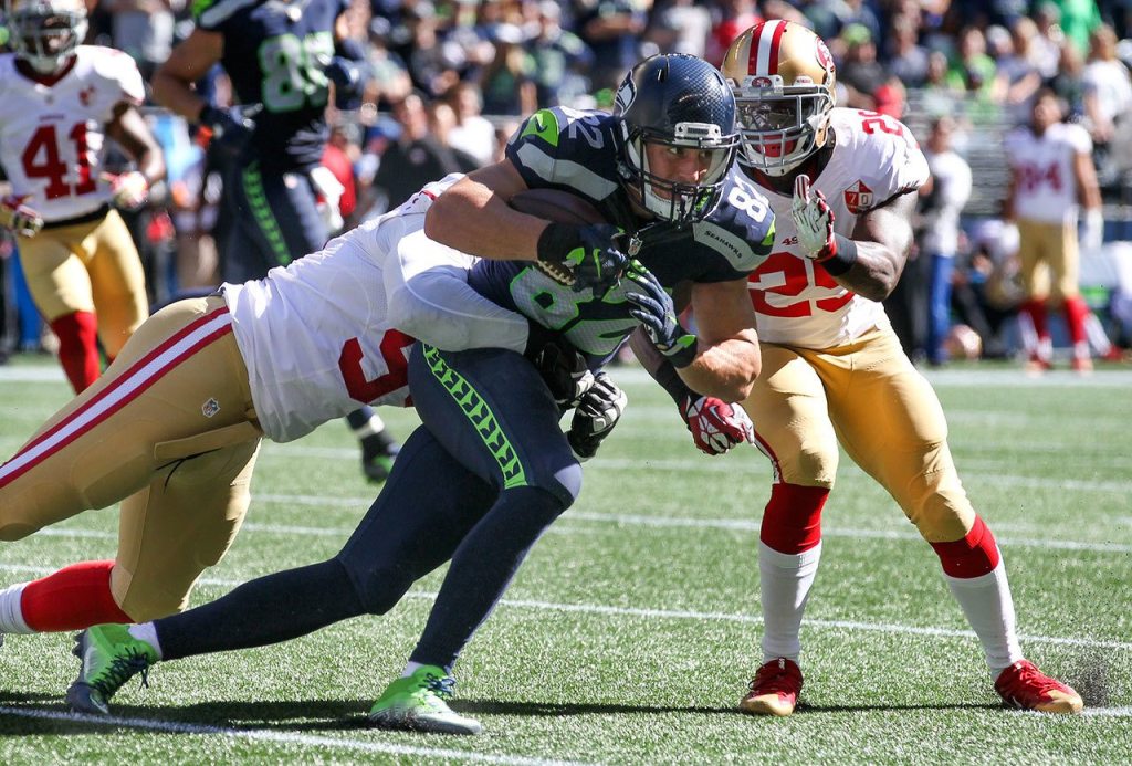 Seahawks tight end Luke Willson struggles for more yards with 49ers linebacker Tank Carradine, left, and 49ers safety Jaquiski Tartt tackling Sunday afternoon at Century Link Field in Seattle on September 25, 2016. The Seahawks are 2-1 after defeating the 49ers 37-18. (Kevin Clark / The Herald)