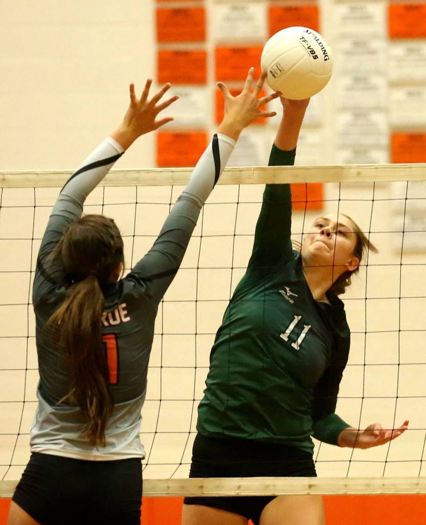 Monroe&rsquo;s Avery Davidson jumps to block a kill attempt by Jackson&rsquo;s Lauren Demoulin Wednesday night at Monroe High School. (Kevin Clark / The Herald)