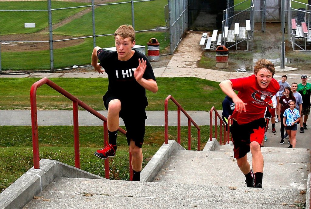 A freshman PE class led by instructor Matt Gale runs races up the steps behind Stanwood High School. It is an area of interest as a new school site.