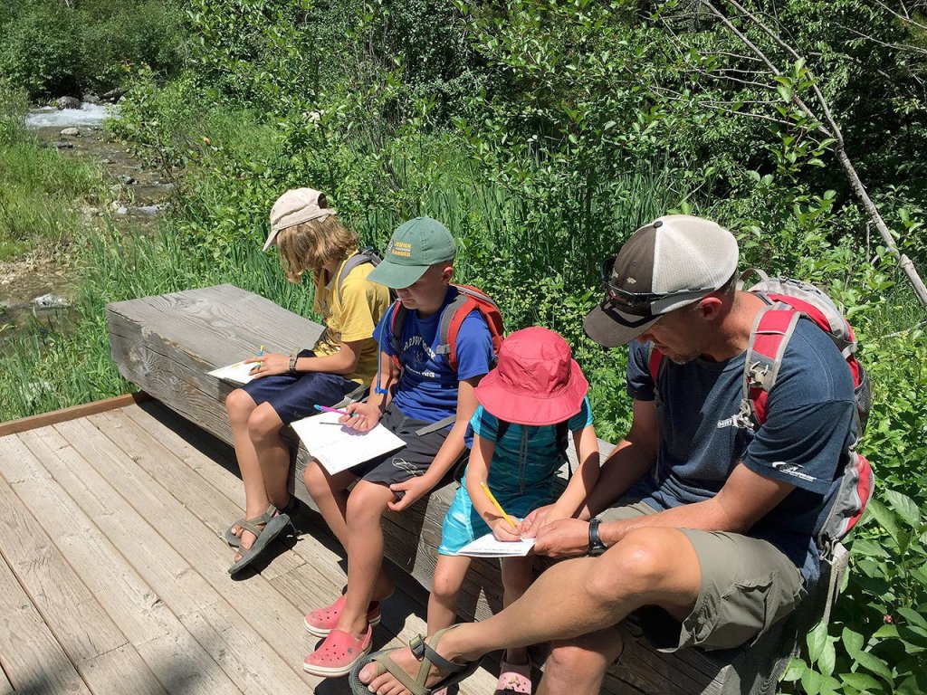 Chris works with the kids on a scavenger hunt needed to complete their Junior Ranger workbooks during a hike in Grand Teton National Park. (Maureen Welcker)