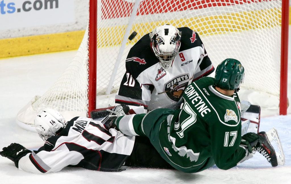 Everett&rsquo;s Matt Fonteyne slides into Giants goalie Gage Ramsay with the Giants&rsquo; James Malm looking on during a game Saturday at Xfinity Arena in Everett. (Kevin Clark / The Herald)
