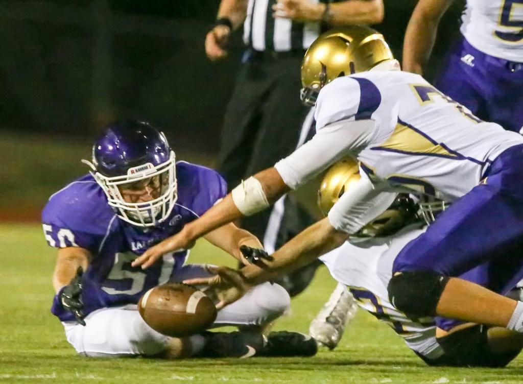 Kamiak&rsquo;s Connor Jones beats Oak Harbor&rsquo;s Ozell Jackson to the fumble by Oak Harbor&rsquo;s Tamarik Hollins-Passmore during a game Thursday night at Goddard Stadium in Everett. (Kevin Clark / The Herald)