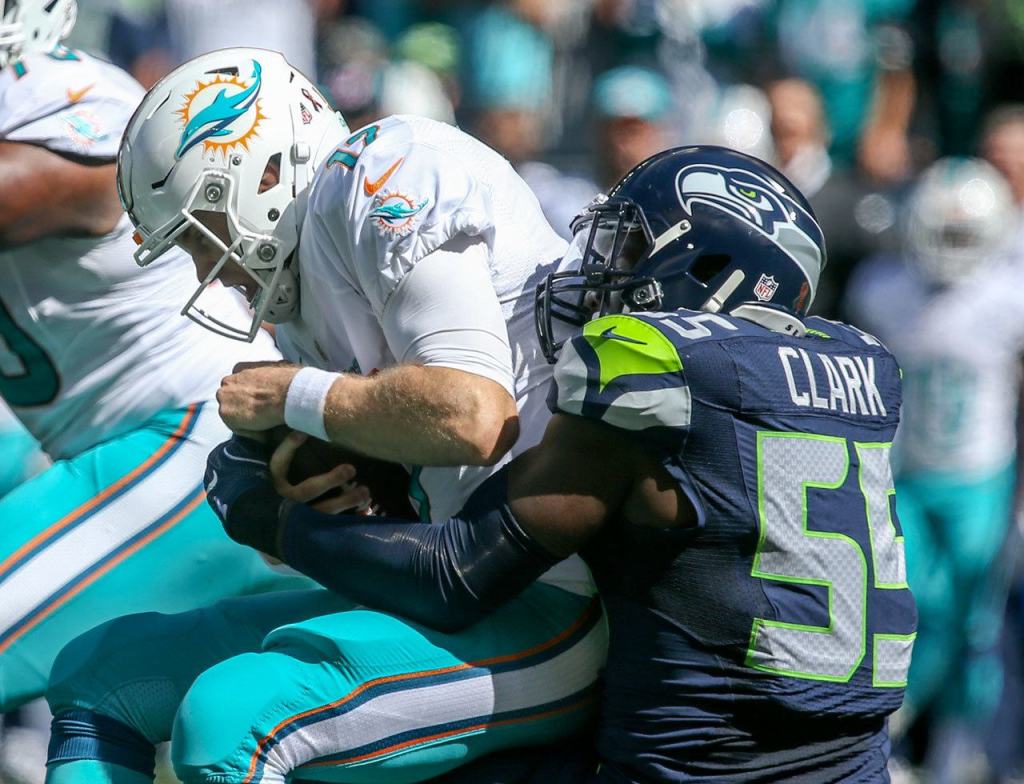Dolphins quarterback Ryan Tannehill is sacked by Seahawks defensive lineman Frank Clark on Sunday at CenturyLink Field in Seattle. (Kevin Clark / The Herald)