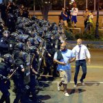 Charlotte-Mecklenburg police officers push protesters from an intersection near the Epicentre in Charlotte, North Carolina, on Wednesday. Authorities tried to quell public anger Wednesday after a police officer shot a black man, but a dusk prayer vigil turned into a second night of violence, with police firing tear gas at angry protesters and a man being critically wounded by gunfire. North Carolina&rsquo;s governor declared a state of emergency in the city. (Jeff Siner/The Charlotte Observer via AP)