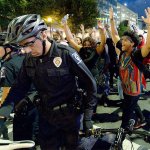 Protesters march behind a bicycle officer along Trade Street in Charlotte, North Carolina, on Wednesday. (Jeff Siner/The Charlotte Observer via AP)