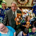 At Shawn O&rsquo;Donnell&rsquo;s, Tuesday night, Snohomish County Sea Hawkers Booster Club members and their president, Nina Therres (left #12) squeeze together with Snohomish County Sheriff Ty Trenary (suit and tie) and a whole bunch of cuddly bears for a photograph. They collected the bears to donate, and Sheriff Trenary will be delivering them to Dawson Place, which serves child victims of sexual or physical abuse. (Dan Bates / The Herald)