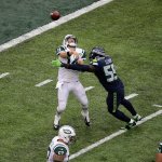 Seahawks defensive end Frank Clark (55) hits Jets quarterback Ryan Fitzpatrick (14) as he throws a pass during a game last Sunday in East Rutherford, N.J. (AP Photo/Peter Morgan)