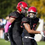 Archbishop Murphy&rsquo;s Anfernee Gurley (right) looks toward his team&rsquo;s sideline as he&rsquo;s congratulated by teammate Jackson Yost after a hit on Olympic quarterback Evan Quitevis during a game at Archbishop Murphy High School on Saturday. (Ian Terry / The Herald)