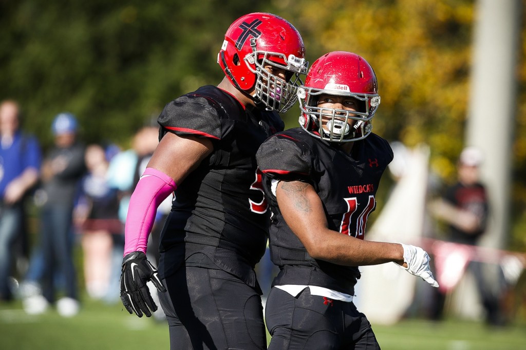 Archbishop Murphy&rsquo;s Anfernee Gurley (right) looks toward his team&rsquo;s sideline as he&rsquo;s congratulated by teammate Jackson Yost after a hit on Olympic quarterback Evan Quitevis during a game at Archbishop Murphy High School on Saturday. (Ian Terry / The Herald)