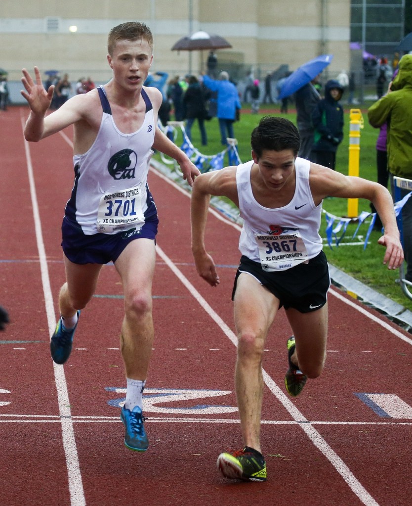 Edmonds-Woodway&rsquo;s Sam McCloughan (left) narrowly edges out Snohomish&rsquo;s Aaron Leavens for third place at the boys 3A District 1 cross country meet at South Whidbey High School on Saturday. (Ian Terry / The Herald)