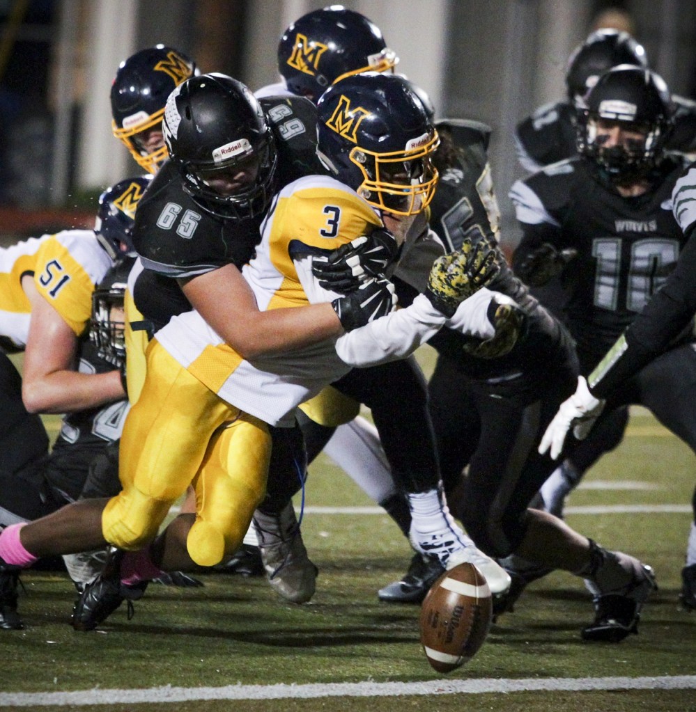 Mariner&rsquo;s Romelo Mangum (3) fumbles on the goal line as he&rsquo;s hit by Jackson&rsquo;s Chase Alexander (65) at the end of the second quarter of a game Friday at Everett Memorial Stadium. (Ian Terry / The Herald)