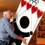 At his home in Everett Thursday, Chris Hoiby moves a door-full of reasons to celebrate the 30th anniversary of the Snohomish County Children&rsquo;s Commission in preparation for next week&rsquo;s event, which will honor past and present volunteers. (Dan Bates / The Herald)