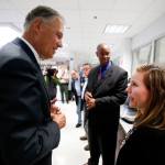 The Washington State Patrol forensic scientist Kristina Hoffman talks with Gov. Jay Inslee while giving a tour of the lab in Marysville on Oct. 6. (Dan Bates / The Herald)