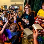 Assistant Principal Carmen Boggs passed out ice cream bars last week to Evergreen Middle School students who acquiredlibrary cards. On Monday, Boggs passed out ice cream bars to those kids and others who could name one thing you cando in a library besides check out books. &ldquo;I was shocked by how many kids didn&rsquo;t know what a library is,&rdquo; Boggs said. &ldquo;SoI started this thing, and it has kind of grown from there.&rdquo; Assisting Boggs is Christopher Bakko, 13. (Dan Bates / The Herald)