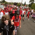 Hunter Gillgan leads Ethan De Soto (wearing mask) during Friday&rsquo;s annual Serpentine Parade, a homecoming tradition for Snohomish High School students. (Andy Bronson / The Herald)