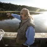 From a research boat on Oct. 12, Tulalip Tribes treaty rights commissioner Terry Williams points out a steep hillside near Mission Beach that has been gradually eroding for years. (Ian Terry / The Herald)