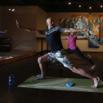 Bluewater Organic Distilling owner John Lundin (center) balances during a YogaMosa session on Saturday, Aug. 6. (Ian Terry / The Herald)