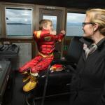 As his mother, Michelle, watches, the Flash (aka Jayden Darnell, 8) pretends to drive the ferry backwards while touring the bridge of the M/V Chelan during the Washington State Ferries&rsquo; first Halloween Costume Contest on Monday, Oct. 31. Crews on ferries picked costume winners from the walk-ons and then escorted one winner to the bridge for the duration of the run. (Andy Bronson / The Herald)